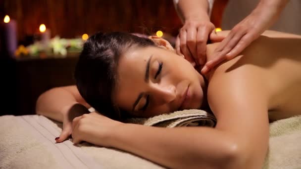Теплая волшебная атмосфера в роскошном спа-центре женщина получает массаж плеч и спины — стоковое видео