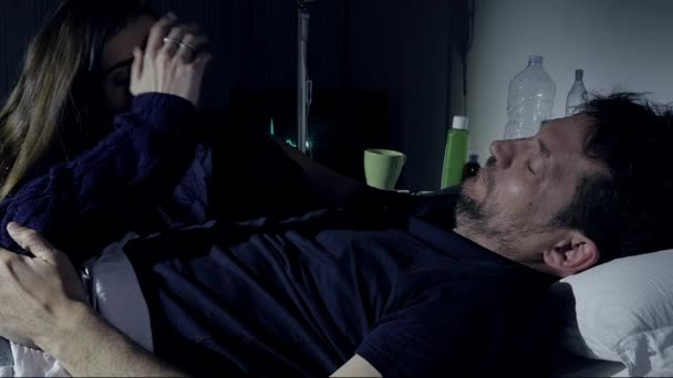 Жінка втішає хворого чоловіка в лікарні вночі — стокове відео
