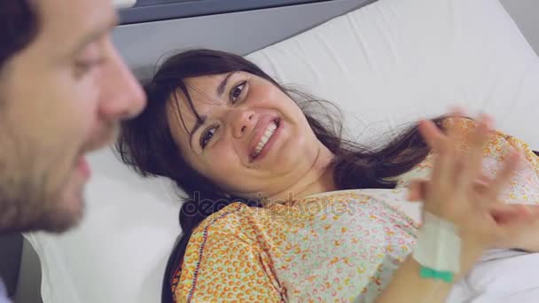 Занепокоєний лікар дає погані новини жінці, що лежить у лікарняному ліжку — стокове відео