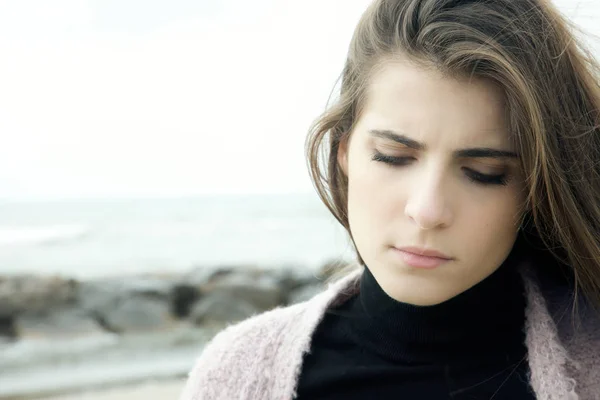 Sad woman  with wind in hair in front of ocean — Stock Photo, Image