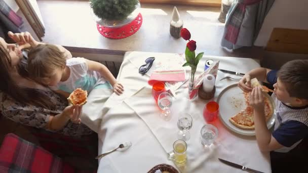 ピザを食べる子供たちと山の中で休暇中のレストランで幸せな家族高いショット — ストック動画