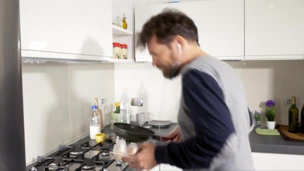 Szczęśliwy Człowiek Kuchni Godzinach Porannych Gotowania Jaj Podczas Tańca Słuchania — Wideo stockowe