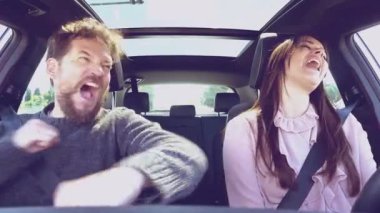 Aşık bir adam ve kadın arabada öpüşüyorlar.