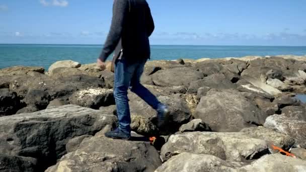 Jovem Homem Moderno Caminhando Sobre Rochas Desfrutando Férias Frente Oceano — Vídeo de Stock