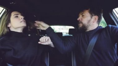 Adam, kız arkadaşının uzun saçlarını çekip bağırıyor ve kızgın araba kullanıyor..