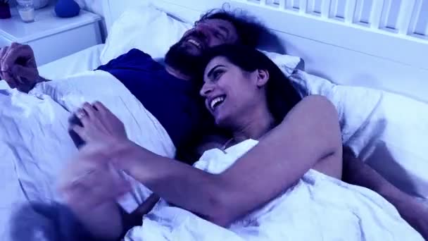 男人让女人抱着笑躺在床上 在夜里抱着 娃娃被枪杀了 — 图库视频影像