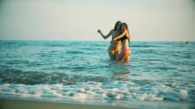 Şirin kız arkadaşlar eğlenmeye yavaş çekim tatil geniş suda dans