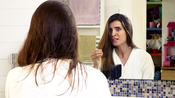 Жінка з проблемою випадіння волосся у ванній відчайдушно — стокове відео