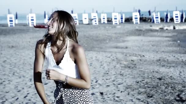 Schattige blonde danser op het strand in de zomer genieten van de zonsondergang Slowmotion — Stockvideo