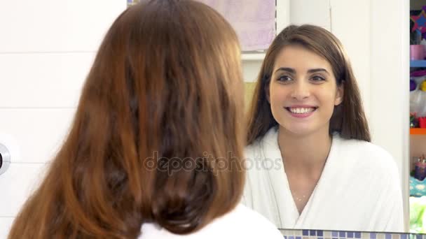 Woman looking teeth in the mirror in bathroom — Stock Video