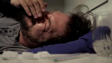 Gün batımında yatakta ağlayan bir adam ağır çekim yakın çekim