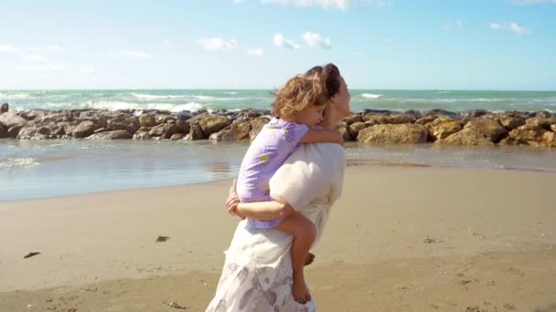 Kobieta Spacerująca Plaży Trzymająca Małą Córeczkę Plecach Uśmiechnięta Rozmawiająca Przed — Wideo stockowe
