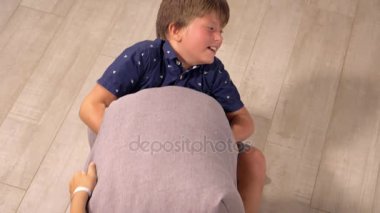 Kız kardeşiyle yastık kavgası yapan sevimli çocuk, yavaş çekimde yakın çekim.