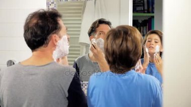 Baba ve oğul tıraş önünde, ayna banyo mutlu yavaş hareket