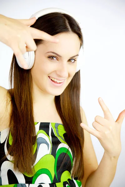 Glad söt tjej lyssnar musik med hörlurar leende ser kameran — Stockfoto