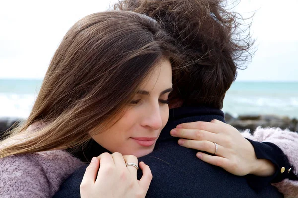 Kobieta zakochana, przytulanie silny mąż przed ocean — Zdjęcie stockowe