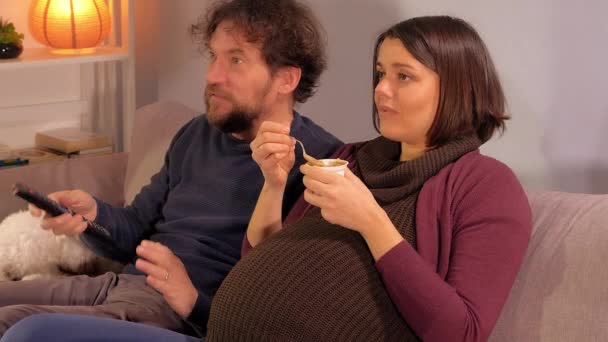 妊娠中の女性と夫はテレビを見てスポーツチームの成功を祝う — ストック動画