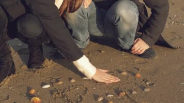 Kışın kumsalda aşık bir kadın deniz kabuğuyla aşk yaşıyor. Mutlu erkek arkadaşı için öpüşüyor.