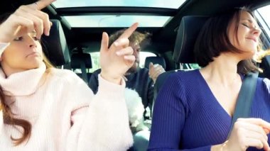 Arabada dans eden insanlarla dalga geçen bir kadın.