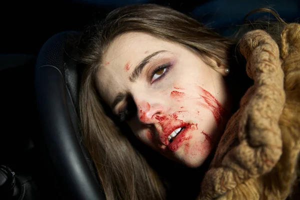 Женщина убита в машине с кровью на лице — стоковое фото