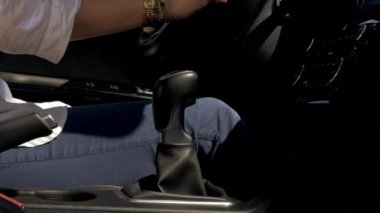Gün batımında araba sürüş sırasında vites değiştirme kadının el
