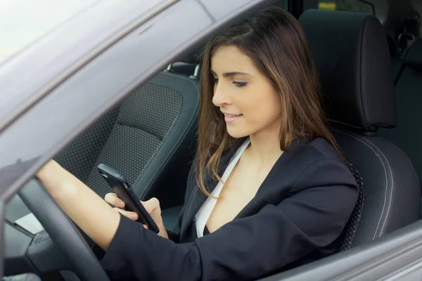 Magnifique jeune femme d'affaires souriant parlant au téléphone dans la voiture — Photo