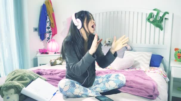 Ευτυχισμένη Φοιτήτρια Που Κάθεται Στο Κρεβάτι Τραγουδώντας Ακουστικά Αργή Κίνηση — Αρχείο Βίντεο