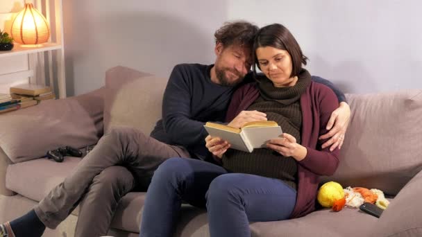 Gravid Kvinna Läser Bok Kysser Man Lycklig — Stockvideo