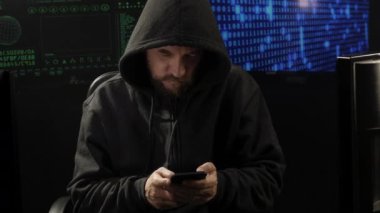 Telefondaki bilgisayar korsanı kısa mesaj yazarken yakın plan çekiyor.