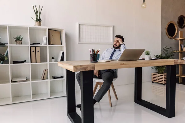 Affärsman sitter vid bordet med bärbar dator — Stockfoto