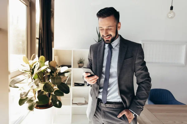 Бизнесмен использует смартфон в офисе Стоковая Картинка