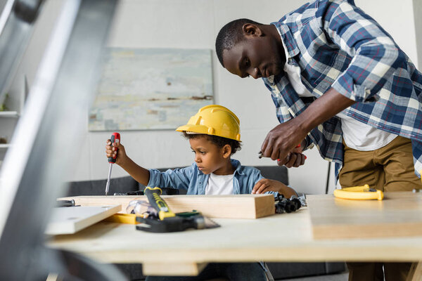 african-american father and son doing renovation