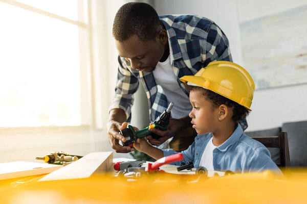 african-american father and son doing renovation