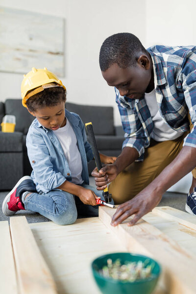 african-american father and son doing renovation