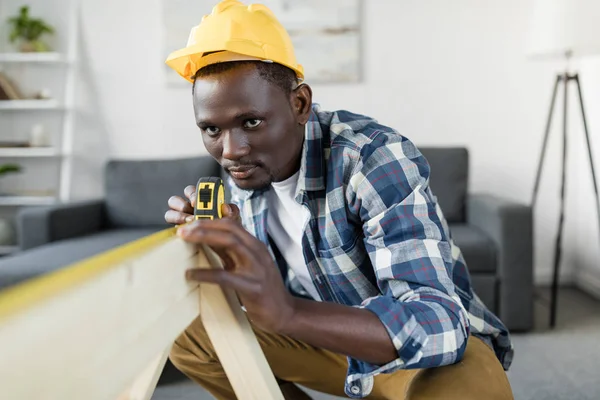 Construtor afro bonito com fita métrica — Fotografia de Stock