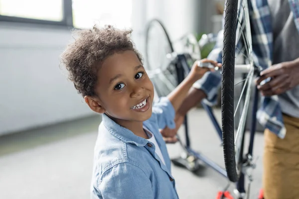 愛らしいアフロ少年修理自転車 — ストック写真