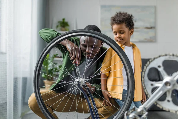 Afro father and son repairing bicycle — Free Stock Photo