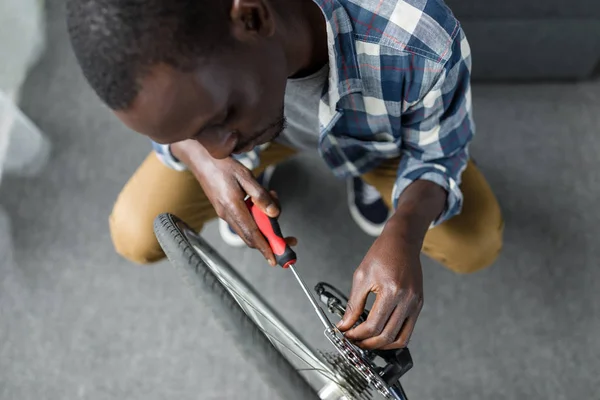 Afro man javítás kerékpár otthon — Stock Fotó