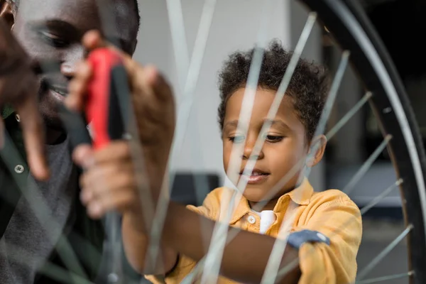 Afro padre e hijo reparando bicicleta — Foto de Stock