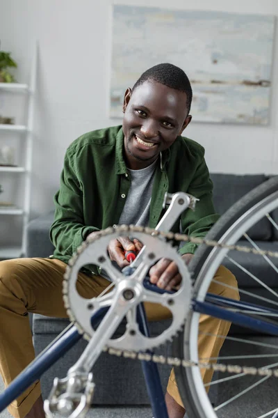Afro man javítás kerékpár otthon — Stock Fotó