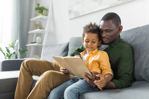 Far och son läser bok tillsammans — Stockfoto