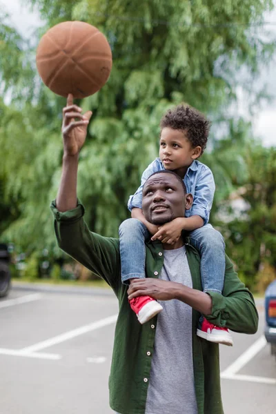 Father spinning ball with son on shouders — Stock Photo, Image
