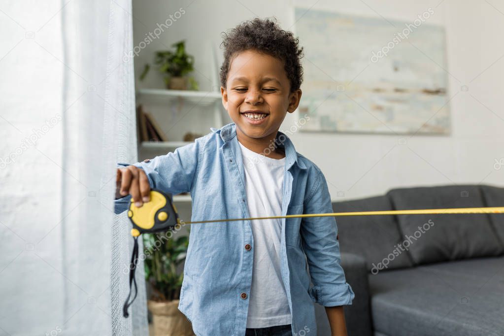 adorable afro boy with measuring tape