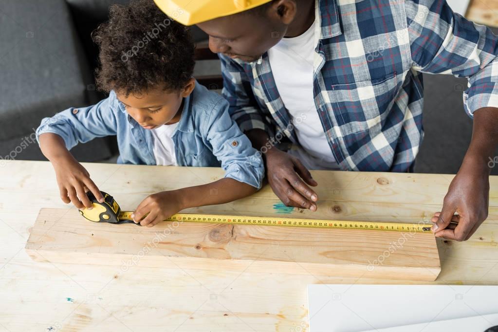 african-american father and son doing renovation