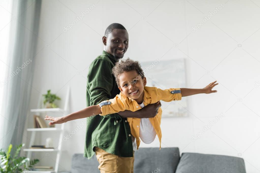 afro father and son playing at home