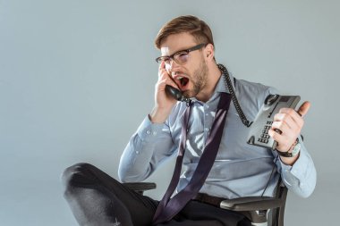 Telefonla konuşurken bağırıyor genç rahatsız işadamı gri izole