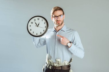Gri izole saati işaret kendine güvenen genç işadamı