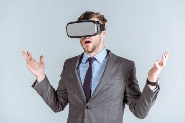 Genç işadamı gri izole vr kulaklık kullanarak