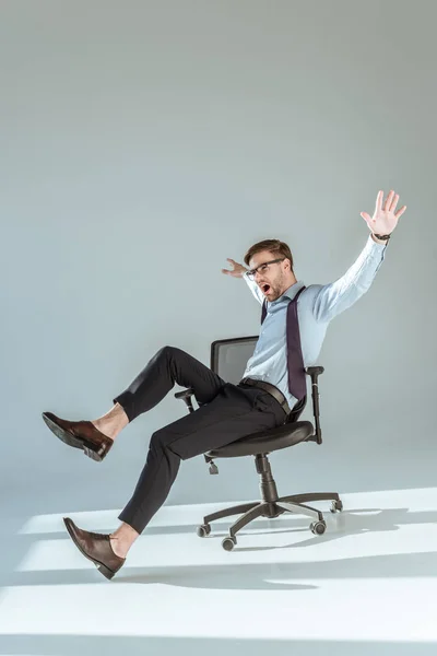手と足を広げて椅子に座って興奮してスタイリッシュなビジネスマン — ストック写真