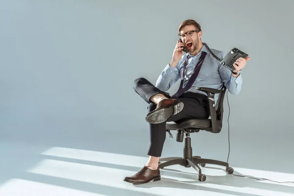 Jovem Empresário Irritado Sentado Cadeira Gritando Enquanto Fala Telefone — Fotografia de Stock